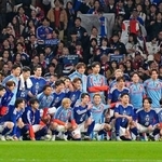 　サッカー国際親善試合でイングランドから初勝利を挙げ、サポーターと写真に納まる日本代表の選手たち＝３月３１日、ロンドンのウェンブリー競技場（共同）