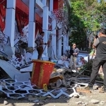 　インドネシア・北スラウェシ州マナドで、地震で損傷した建物を調べる警察官＝２日（ＡＰ＝共同）