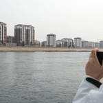 　鴨緑江を挟んで中国の対岸にある北朝鮮の新義州周辺＝３月、中国遼寧省丹東から撮影（共同）