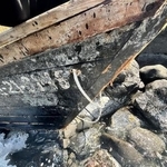 　鳥取県湯梨浜町の海岸に漂着した木造船。外板にハングルが記載されている＝３日（境海上保安部提供）