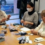 　しおりにリボンを通す「空色の会」のメンバーら＝４日、兵庫県川西市