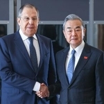 　昨年２月、南アフリカ・ヨハネスブルクでの会談で握手する中国の王毅外相（右）とロシアのラブロフ外相（タス＝共同）