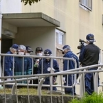 　集合住宅の入り口付近で現場検証をする大阪府警の捜査員＝９日午前１１時５１分、大阪府和泉市