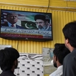 　米イラン協議について伝える地元テレビ放送を見つめるパキスタンの市民＝１０日、イスラマバード（ロイター＝共同）