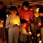 　熊本地震の「前震」から１０年となり、発生時刻に黙とうする子どもら＝１４日午後９時２６分、熊本県益城町