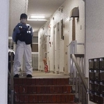 　冷凍庫に入った男性の遺体が見つかった集合住宅を警戒する警察官＝６月２０日、神戸市中央区