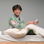 　パジャマ姿で寝付き対策を実践する松丸亮吾＝東京都中央区