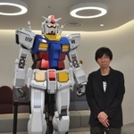 　小形尚弘とガンダム像＜（Ｃ）創通・サンライズ＞