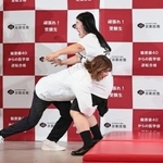 　よしこ（右）にタックルする吉田沙保里さん＝東京都港区
