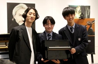 　昨年「かてぃんピアノ」を借りた高校生たちと写真に収まる角野隼斗＝東京都内