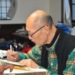 　執筆する藤田和日郎さん