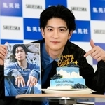 　サプライズで用意された誕生日ケーキを前に、写真集を手にする中島裕翔＝５日、東京都千代田区