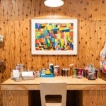 　ヘラルボニー店内に展示されたアート作品。手前は週末に作家が創作活動を行う机。制作に必要な美術道具が並んでいる＝東京・銀座（提供：ヘラルボニー）