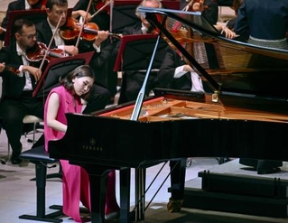 　ショパンのピアノ協奏曲を演奏するピアニストの小林愛実さんと、ワルシャワ国立フィルハーモニー管弦楽団＝８月、大阪市此花区の夢洲