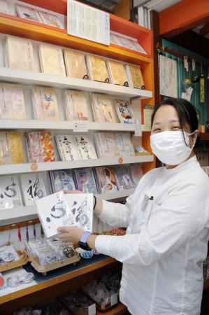 　売れ筋の御朱印帳を手にする丹下めぐみさん＝東京都台東区