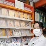 　売れ筋の御朱印帳を手にする丹下めぐみさん＝東京都台東区