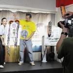 　男性ファンが持参したくす玉を割る山西アカリさん（左）＝東京都台東区