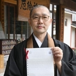 　点字おみくじを持つ根本聖道さん＝東京都中野区