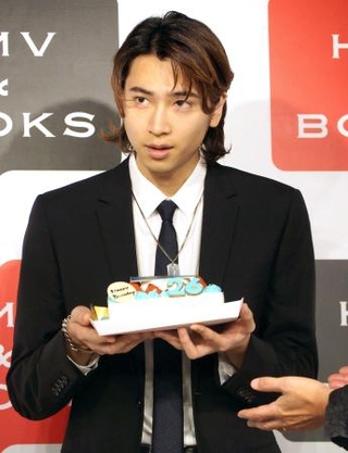 　誕生日祝いのケーキを手にする庄司浩平＝東京都渋谷区