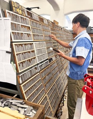 　活字を拾う職人＝東京都新宿区