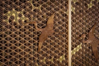 　八芳園メインロビー壁面を飾る福岡県大川市の組子細工。夫婦鶴の彫刻をあしらった（提供写真）