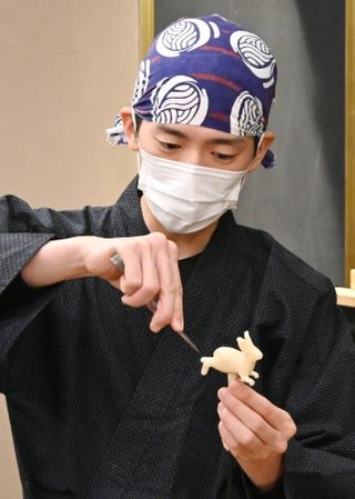 　はさみを使ってウサギを作るあめ細工職人＝東京都台東区