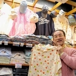 　お薦めのシャツを手にする相羽岳男さん＝東京都台東区