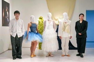 　衣装を着たダンサーと並ぶ堀内将平さん（左端）と井上ユミコさん（右端）＝東京都渋谷区