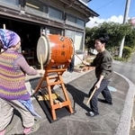 　青空の下、店先で八丈太鼓を演奏する渡辺志保さん（左）と晴万さん＝東京都八丈町