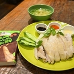 　「夢飯」の人気メニュー、チキンライス（右）と、「にわとり文庫」で購入した伊坂幸太郎さん著「陽気なギャングの日常と襲撃」の文庫本＝東京都杉並区
