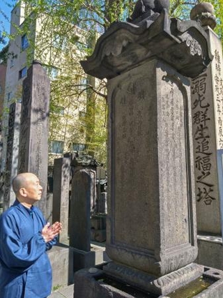 　明暦の大火の犠牲者を供養する塔の前に立つ本多将敬さん＝東京都墨田区