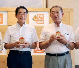 　「ひめの琥珀」を手に記念撮影に応じる愛媛県の中村時広知事（左）と小谷順一さん＝６月、県庁