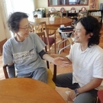 　「リュッケみいけ」で入居者の女性（左）と話す運営法人代表理事の梶原崇志さん＝７月、堺市（撮影のためマスクを外しています）