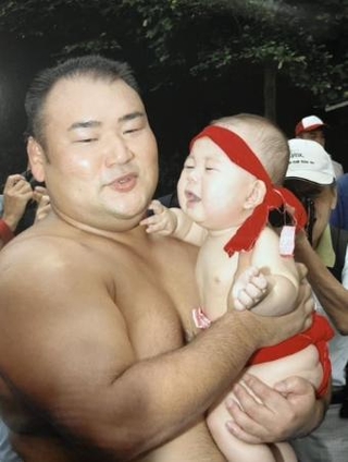 　父の甲山親方（元幕内大碇）に抱っこされる０歳の頃の若碇＝２００５年、京都市の松尾大社
