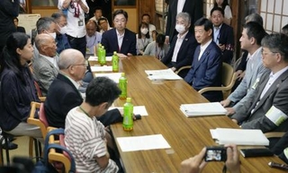 　「水俣病センター相思社」で開かれた、伊藤環境相（当時、右列手前から３人目）と水俣病患者連合の再懇談＝７月、熊本県水俣市
