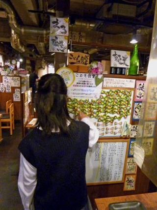 　居酒屋「浩治朗」の入り口に貼られたリボンを取る子ども＝埼玉県和光市