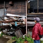 　土砂崩れに巻き込まれ、倒木が壁を貫通した家屋を見つめる高野皓さん＝２０２４年１１月、石川県輪島市町野町の寺山地区