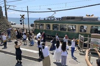 　訪日外国人客らで混雑する江ノ島電鉄「鎌倉高校前駅」近くの踏切＝２０２３年７月、神奈川県鎌倉市