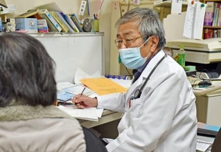 　診療所で診察する安梅正則医師＝２０２４年１２月、鳥取県倉吉市