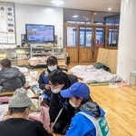 　石川県能登半島の避難所で、被災者の心のケアにあたるＤＰＡＴの隊員（右手前）ら＝２０２４年２月（國井泰人准教授提供）
