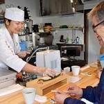 　立ち食いすし店「寿しらぼ三〇二」で、客（右）にすしを握る副業職人の斎藤ちひろさん＝２０２５年１月、静岡県下田市