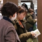 　書店「食べる本屋さん」で本を手に取る客＝２０２５年２月、津市の松菱百貨店