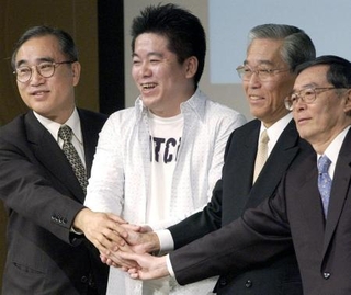 　ニッポン放送経営権をめぐる争奪戦が和解し、記者会見で握手する（左から）ニッポン放送の亀渕昭信社長（当時）、ライブドアの堀江貴文社長、フジテレビの日枝久会長と村上光一社長＝２００５年、東京都港区のホテル
