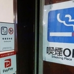 　喫煙可能な居酒屋の入り口に張られた「喫煙ＯＫ」と書かれた紙＝２月、東京都千代田区
