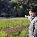 　土砂が流入した田んぼを指さす川原伸章さん＝石川県輪島市
