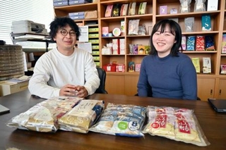 　取材に応じる「日の出屋製菓産業」の川合洋平社長（左）と海外販路の担当社員＝２０２５年３月、富山県南砺市
