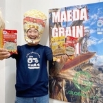 　商品化したポップコーンを手にポーズをとる農家の前田茂雄さん＝２０２５年４月、北海道本別町