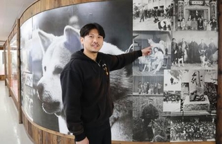 　「秋田犬会館」の展示について説明する秋田犬保存会事務局長の庄司有希さん＝秋田県大館市