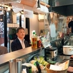 　青森県八戸市の屋台村「みろく横丁」で、カウンターに座る宮本明宗さん（中央）