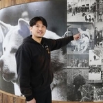 　「秋田犬会館」の展示について説明する秋田犬保存会事務局長の庄司有希さん＝秋田県大館市